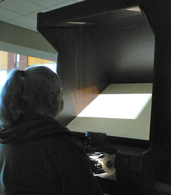 Woman using a microfilm reader.