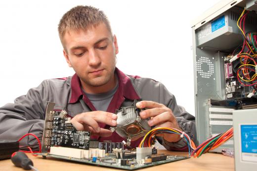 A computer technician works on computer.