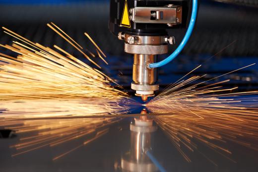 A laser cutter is used to cut a sheet of metal.