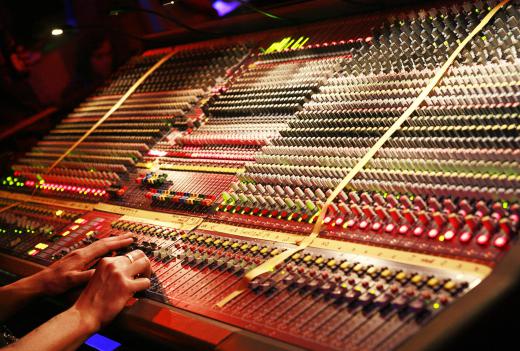 An engineer using a sound mixer in a professional recording studio.